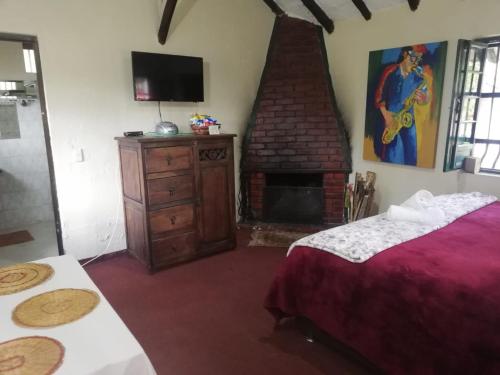 a bedroom with a bed and a brick fireplace at Hotel y Centro de Convenciones Pueblito de Yerbabuena Paraíso Natural in Chía