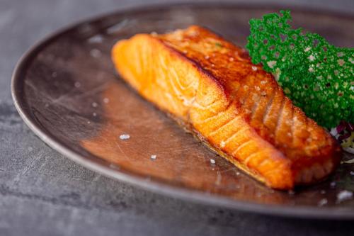 a plate with a piece of fish and a piece of broccoli at La Svolta in Chiuro