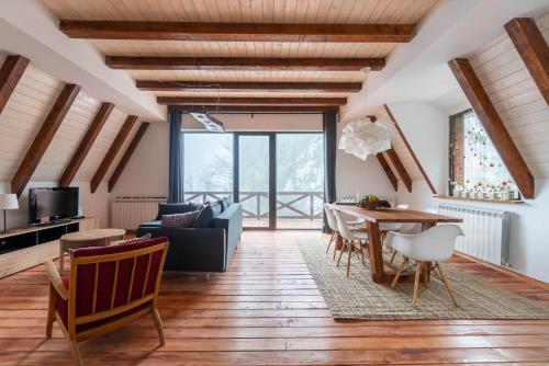 a living room with a wooden floor and a table at Vista Mountain House in Kopaonik