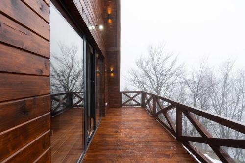 a room with a balcony with a view of the woods at Vista Mountain House in Kopaonik
