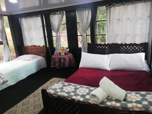 a bedroom with two beds and a window at Hotel y Centro de Convenciones Pueblito de Yerbabuena Paraíso Natural in Chía