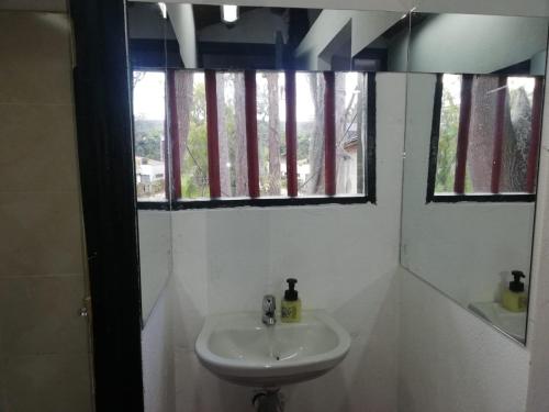 a white bathroom with a sink and two windows at Hotel y Centro de Convenciones Pueblito de Yerbabuena Paraíso Natural in Chía