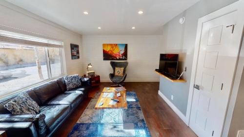 a living room with a leather couch and a table at Moab Flats #7 in Moab