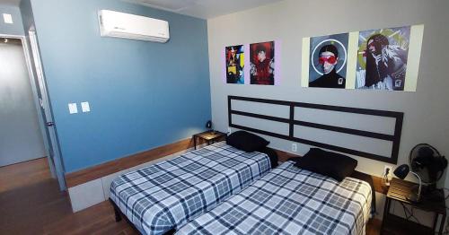 1 dormitorio con 2 camas y carteles en la pared en Hotel Sttiny Monterrey Tecnológico, en Monterrey