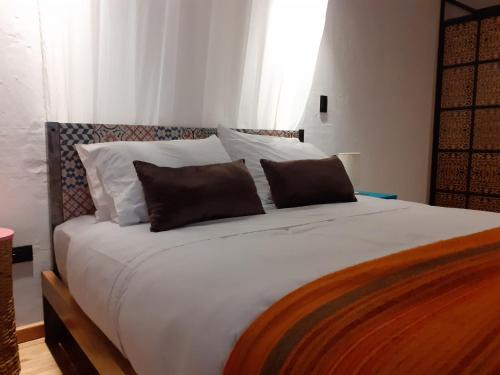 a large white bed with two pillows on it at Hostal Suite Le Fabrique in Cuenca
