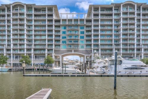 a large building with a marina and boats in the water at The Whart Unit 505 condo in Orange Beach