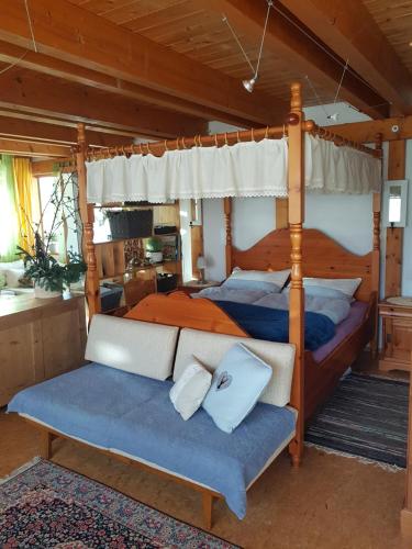 1 Schlafzimmer mit 2 Betten und einem Himmelbett in der Unterkunft Zentrale Ferienwohnung auf dem schönen Hunsrück in Halsenbach