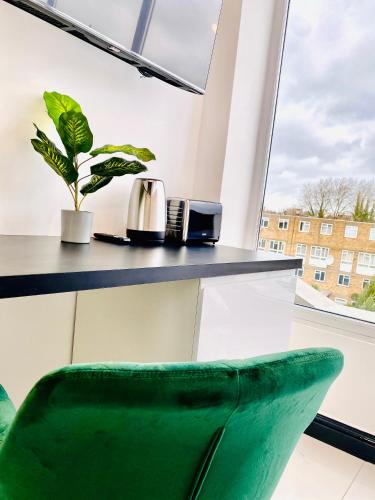 a green chair in front of a counter with a window at Duke and Duchess Apartments and Rooms - Private in Room Hot Tub Suites in London