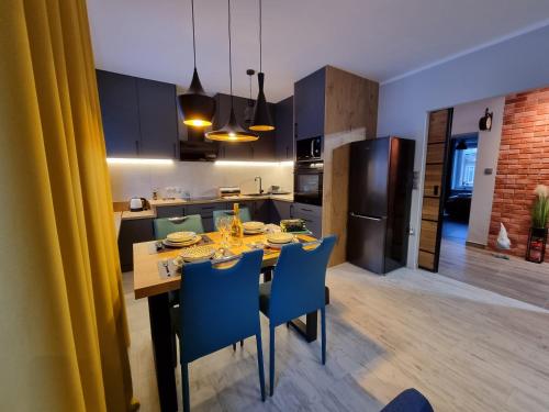 een keuken en eetkamer met een tafel en stoelen bij Apartament LuxLoft in Piechowice