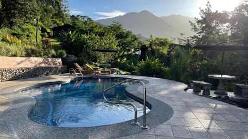 a swimming pool with a hot tub in a backyard at Hotel de Montaña El Pelicano in San Isidro
