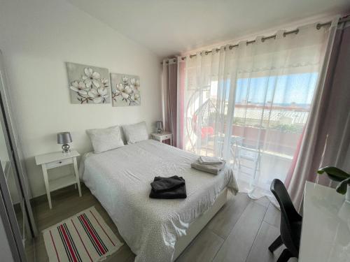 um quarto com uma cama e uma grande janela em Casa Luztour na Praia da Luz