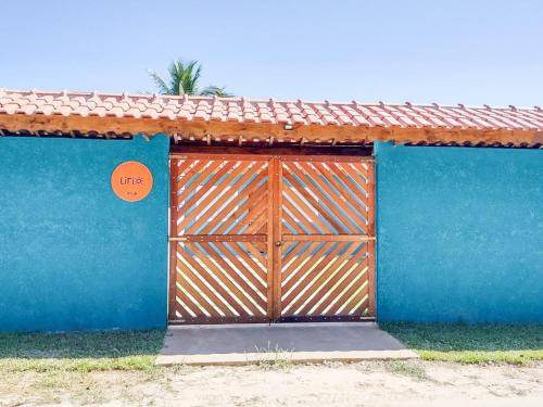 a blue building with a wooden gate with a sign on it at Mare de Lua Boraceia in Boracéia