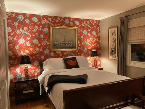 a bedroom with a bed with red floral wallpaper at Derinda House in Elizabeth