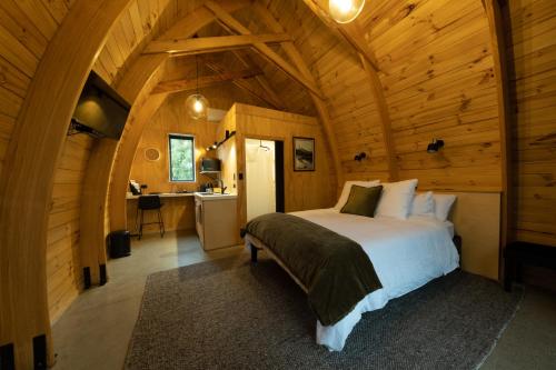 a bedroom with a bed in a wooden cabin at Benger Garden Chalets in Millers Flat