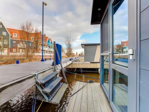 福伦丹Houseboat in Volendam near Fort Edam的建筑物旁边码头上的长椅
