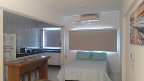 una pequeña cocina con una pequeña cama en una habitación en Studio novo - Vai te surpreender, en Praia Grande