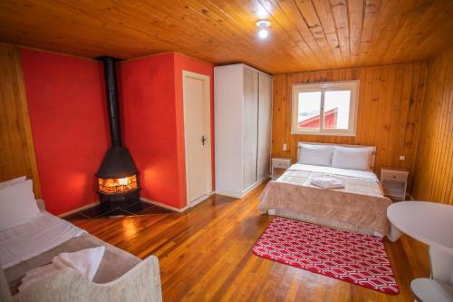 a bedroom with two beds and a fireplace in a room at Pousada Morada do Sol in Cambará