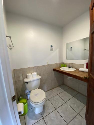 a bathroom with a toilet and a sink at Mariposa Lodge in West End