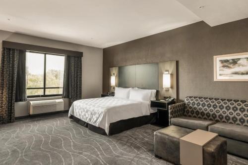 a hotel room with a bed and a couch at Holiday Inn & Suites Silicon Valley - Milpitas by IHG in Milpitas