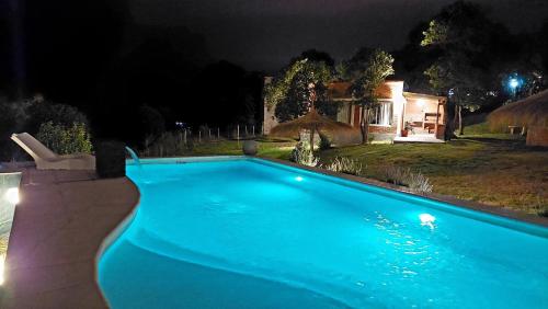 a blue swimming pool in a yard at night at Los Molles Suites -Solo 2 Pax- in Mina Clavero