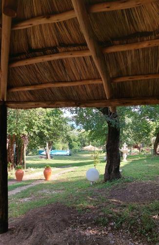 a porch with a tree and a wooden roof at Los Molles Suites -Solo 2 Pax- in Mina Clavero