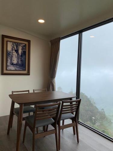a dining room with a table and chairs and a large window at Song Mao Homestay in Leye