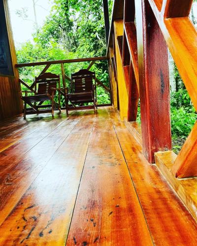 a porch with two benches on a wooden deck at Sunrise of Tambopata in Puerto Maldonado