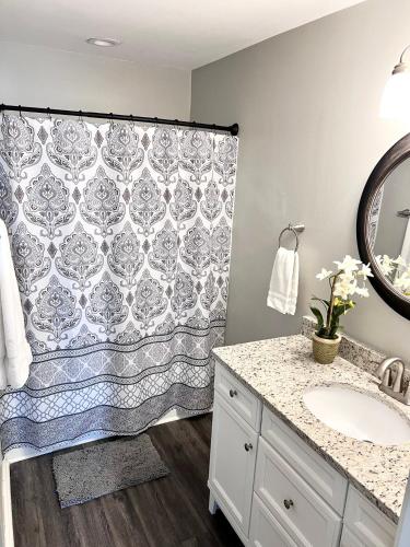 a bathroom with a shower curtain and a sink at Change in Attitude - 2BR Condo Golfin’, Fishin’, Beachin’ Everyday in Edisto Island
