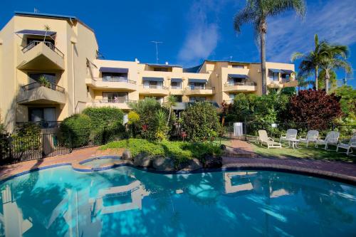 a hotel with a swimming pool in front of a building at Grangewood Court Apartments in Gold Coast