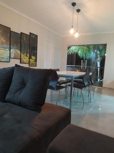 a living room with a couch and a dining room table at Casa Temporada Waldemar Damasceno - Beira Rio com piscina in Piranhas