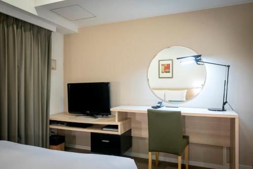 a hotel room with a desk with a mirror and a television at B:CONTE Asakusa in Tokyo