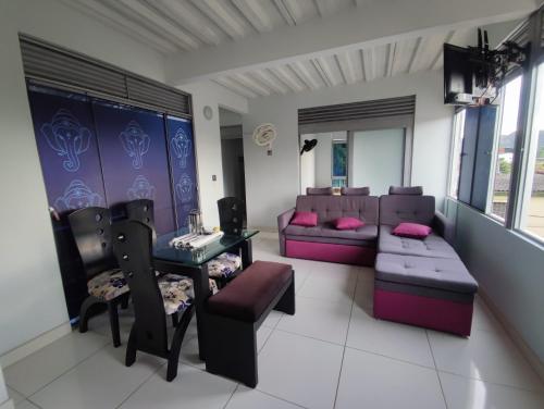 a living room with a couch and a table and chairs at Nirvana Casa de Huéspedes in Melgar