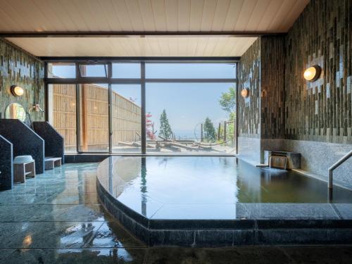 a large pool of water in a room with a large window at Lake View Inawashiro in Inawashiro