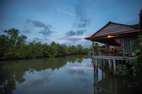 a house on the side of a river at Kampot Cabana in Kampot