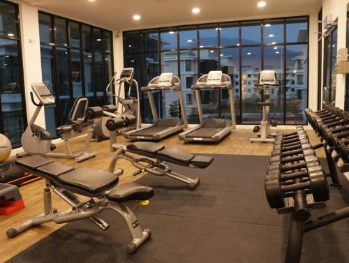 a gym with several treadmills and machines in a building at Family Staycation BYSS Homestay in Kampar