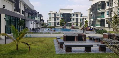 a park with benches in a courtyard with buildings at Family Staycation BYSS Homestay in Kampar