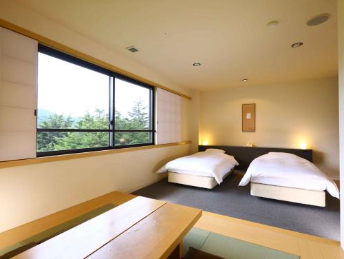 A bed or beds in a room at Manza Onsen Nisshinkan