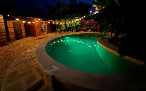 a small swimming pool at night with lights on it at Luhme Tulum Hostel - Free Cenote Access in Tulum