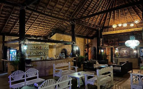 a restaurant with white chairs and a bar at Luhme Tulum Hostel - Free Cenote Access in Tulum