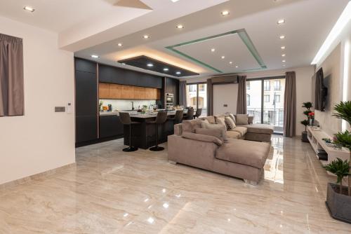 a living room with a couch and a kitchen at Luxury 2 bed apartment in the heart of St Julians in St. Julianʼs