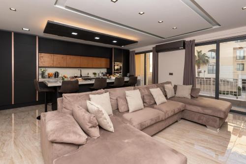 a living room with a couch and a kitchen at Luxury 2 bed apartment in the heart of St Julians in St. Julianʼs