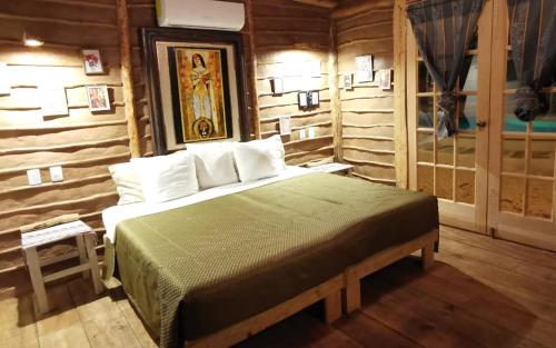 a bedroom with a bed in a room with wooden walls at Luhme Tulum Hostel in Tulum