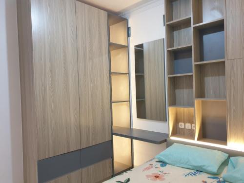 a bedroom with a bed and a desk and shelves at Guest House Omah Ningrat Bandung in Bandung