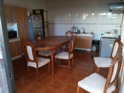 uma cozinha com uma mesa de madeira e 4 cadeiras em Colbun em Colbún