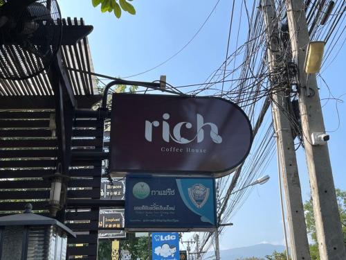 a sign for a coffee shop on a street at Rich Lanna House in Chiang Mai