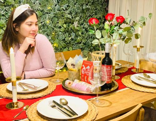 a young woman sitting at a table with a table cloth at Private lodging in WEST TOKYO(SHINJUKU, TACHIKAWA, SANRIO, GHIBLI, MT. TAKAO etc) in Kokubunji