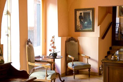 a room with two chairs and a table and a window at Hotel Don Carlos Cáceres in Cáceres