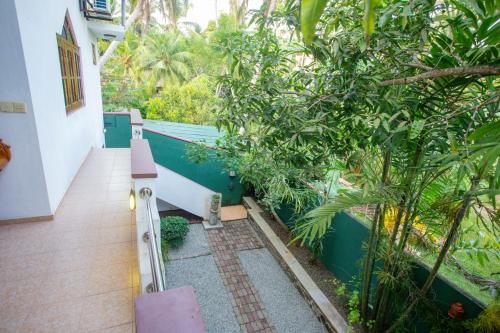 a stairway leading up to a house with trees at Green Villa Apartment in Unawatuna
