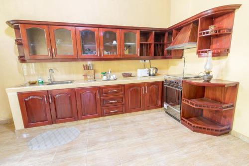 a kitchen with wooden cabinets and a sink at Green Villa Apartment in Unawatuna
