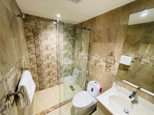 ein Bad mit einer Dusche, einem WC und einem Waschbecken in der Unterkunft اطلالة الشرفة 2 -Terrace View 2 in Khobar